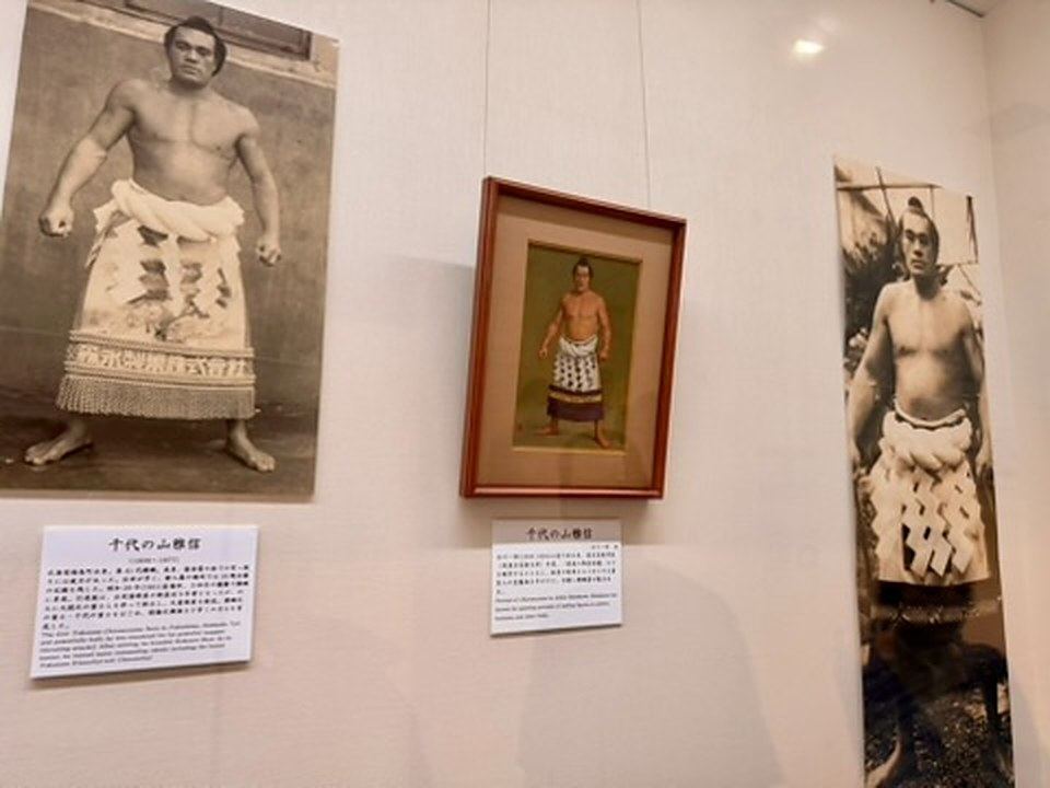 博物館の壁に展示された、化粧廻し姿の横綱・千代の山の大きな写真と額装の肖像