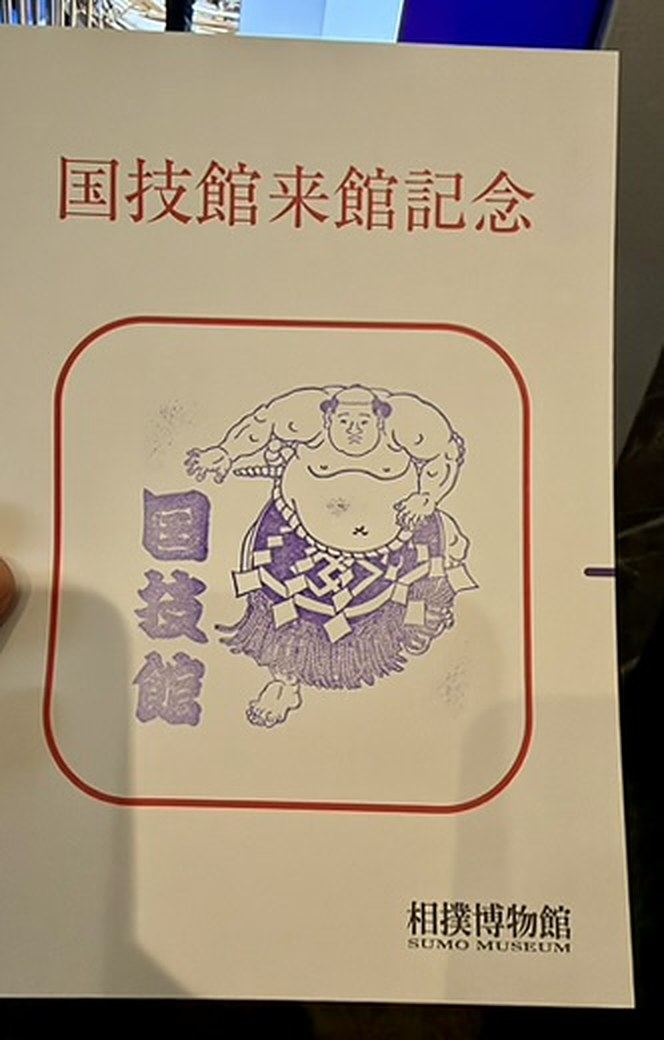 相撲博物館の来館記念用紙に押された、力士と「国技館」の文字が入った紫色のスタンプ